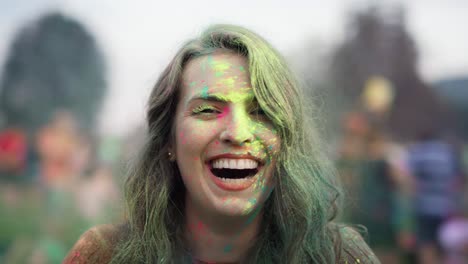 close up of caucasian woman looking at camera at holi festival.