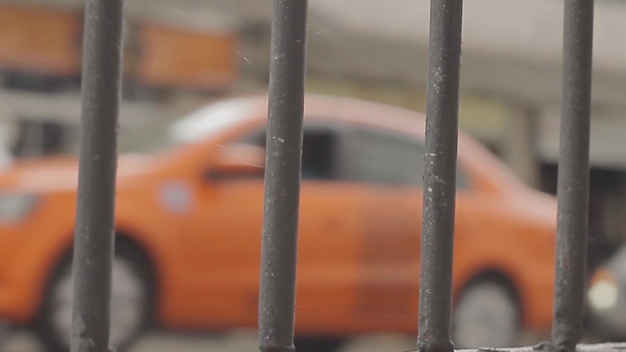 Vista di una finestra dall'interno di una vecchia cella di prigione in una città fredda e trafficata con auto che passano all'esterno