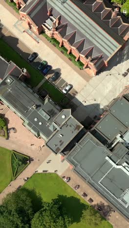 travelling overhead social ratio aerial video of queen's university, belfast on a bright and sunny day. filmed in 1080x1920, 60fps and with rec709 color