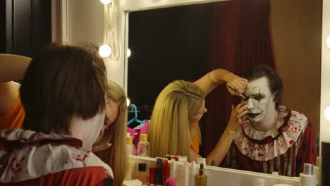 makeup artist applying clown makeup for a halloween event