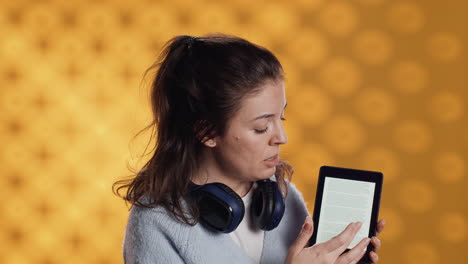 Mujer-Haciendo-Promoción-Para-Leer-Tableta,-Mostrando-Características,-Fondo-De-Estudio