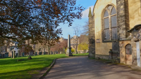 Morning-light-spreads-on-old-scenic-church-grounds-of-Edinburgh-Scotland-with-leafless-trees