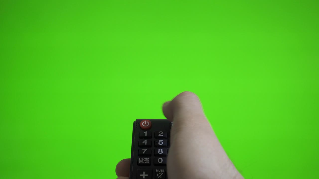 리모컨을 들고 있는 남성의 손이 tv를 녹색 스크린 위로 켜고 광고를 찍습니다.