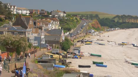 seafront of budleigh salterton. old houses, strolling people, colorful boats on the beach. jurassic coast, east devon area of outstanding natural beauty, england. crop