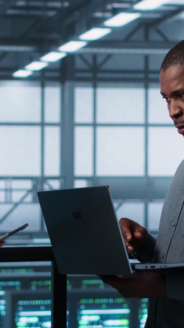 Vertical video Server farm workers using devices to perform vulnerability scans