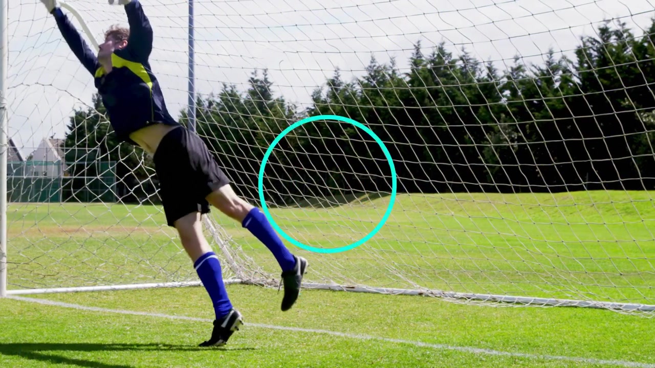 Male goalkeeper rising and tracking off-frame cue, leaping into goal net during sports training