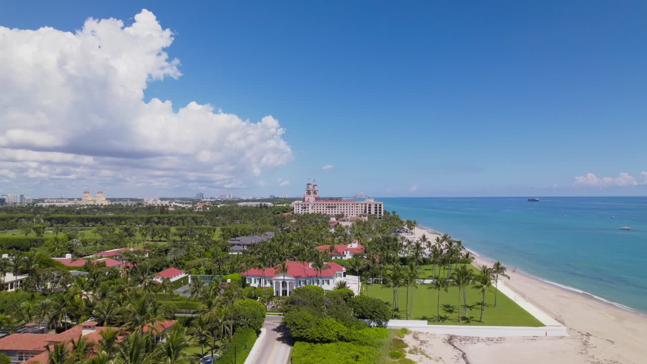 Bird's eye Aerial drone building in foreground view of west palm beach skyline downtown area and beautiful beach sand and boats in water