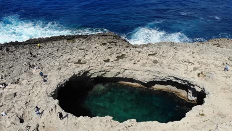 aerial top view of coral lagoon in armier bay in mellieha, malta , tilt down