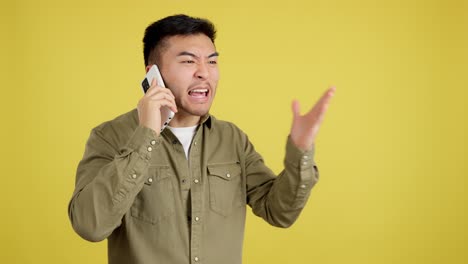 asian man engaged in an expressive phone conversation showing various emotions