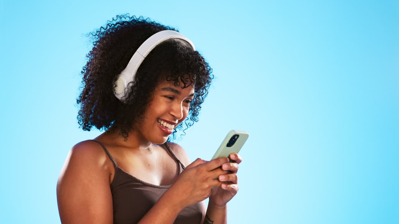 Donna di colore, telefono e cuffie isolate su sfondo blu