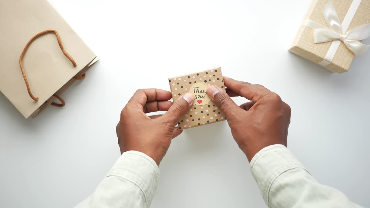 persona que envuelve una caja de regalos