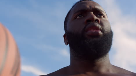 focused african american sportsman practicing basketball outside.