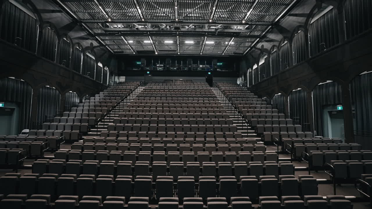 asientos vacíos plegados dentro de la sala de teatro con luces encendidas antes del comienzo de un espectáculo