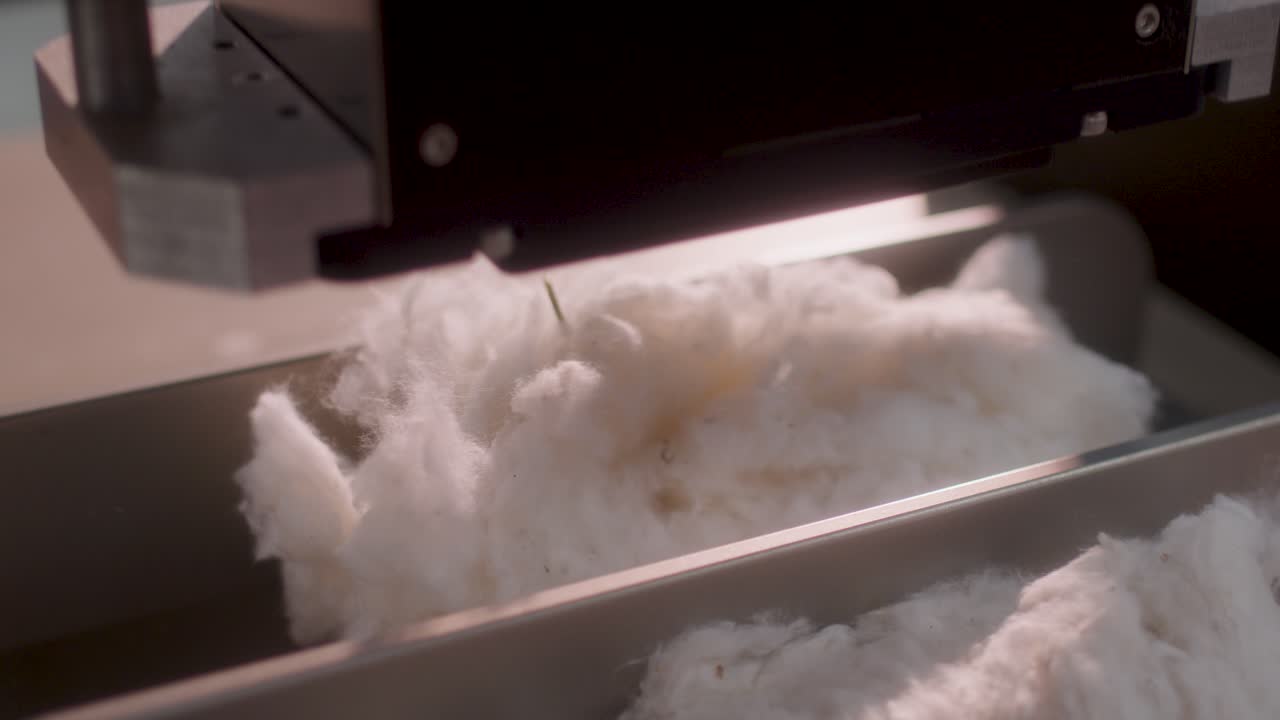 Immagine ravvicinata di cotone grezzo in una macchina automatizzata per la produzione tessile