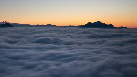 El-Tiempo-Del-Atardecer-De-Día-A-Noche-Transcurre-Por-Encima-De-Una-Inversión-De-Nubes-En-Los-Alpes-Suizos-Visto-Desde-Rigi,-Suiza,-Con-Vistas-A-Las-Montañas-Y-Las-Estrellas-Y-Alejar-El-Zoom