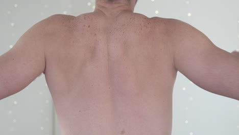 un hombre sin camisa estirando los hombros y los codos, haciendo hincapié en los músculos de la espalda y la alineación del cuello. concepto de aptitud física, postura corporal y conciencia de la salud.