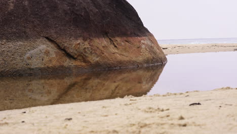 playa de movimiento deslizante que revela rocas, golpea y se mueve sobre la arena