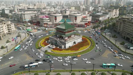 Toma-Aérea-De-Establecimiento-De-Viajeros-Conduciendo-Alrededor-Del-Famoso-Campanario-De-Xian