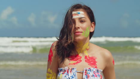 A-girl-on-a-Caribbean-beach,-adorned-in-body-paint-and-a-bikini,-savors-the-sunny-weather-close-up