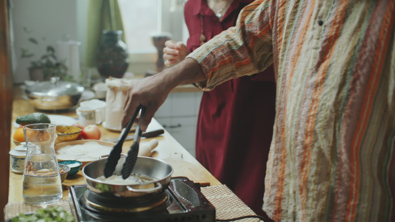 mujer aprendiendo a hacer puris durante la clase de cocina con un chef indio