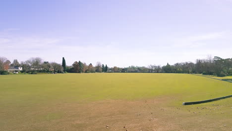 aerial - flying low over the green at a golf club, wide shot forward