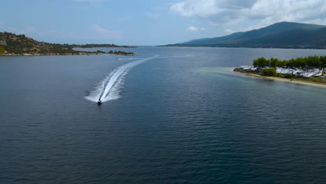 4K-Drohnenclip,-Der-Sich-Langsam-Rückwärts-Bewegt,-Wobei-Sich-Ein-Jetski-In-Der-Bucht-Von-Vourvourou-In-Chalkidiki,-Nordgriechenland,-Nähert