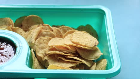 tortilla chips and salsa in a plastic tray