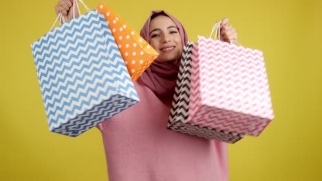 happy woman in hijab holding shopping bags