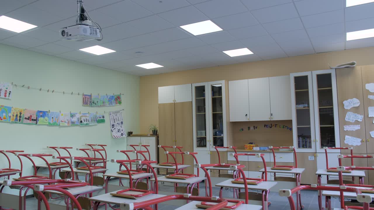 empty classroom during covid19 with chairs and desks stacked on top of each other
