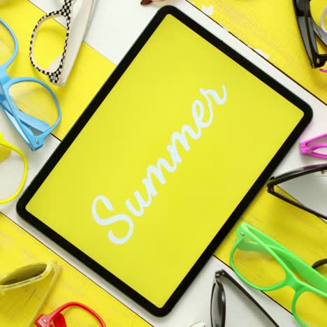 Various-style--shape-and-colour-sunglasses--Tablet-in-the-middle-with-text-SUMMER-