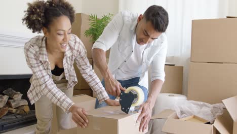 pareja grabando cajas mientras empacan su casa