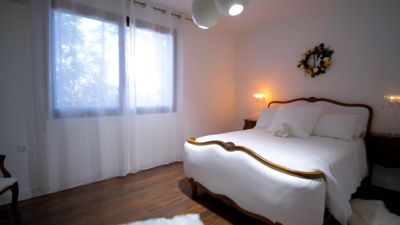 Slow establishing shot of a master bedroom with a white minimalism decoration