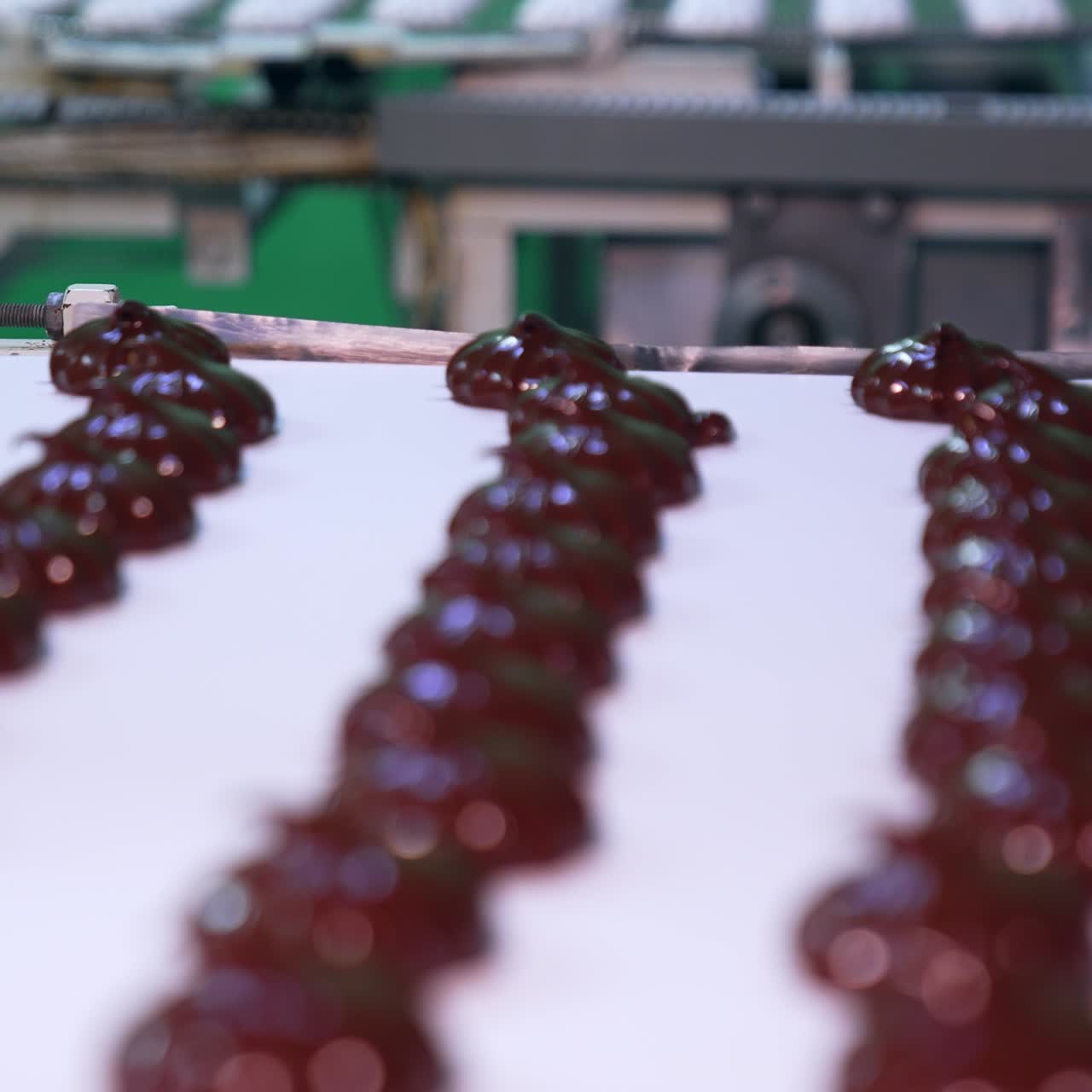 Automated line for production sweet desserts at food factory. Conveyor belts with white marshmallows and those covered with chocolate