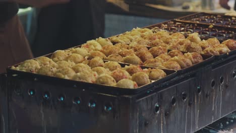 在日本京都的食品市場上, 厨师的手在煮日本零食,