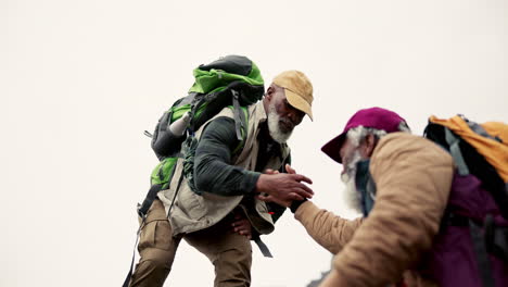 hikers with backpacks climbing a mountain
