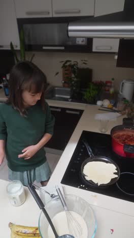 little girl making pancakes