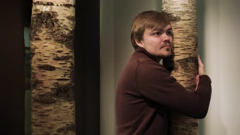 man hugging a birch tree trunk