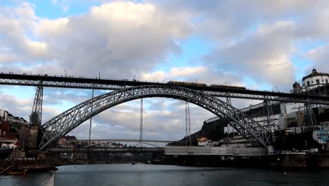 train on dom luis i bridge as seen from douro river aboard rabelo boat