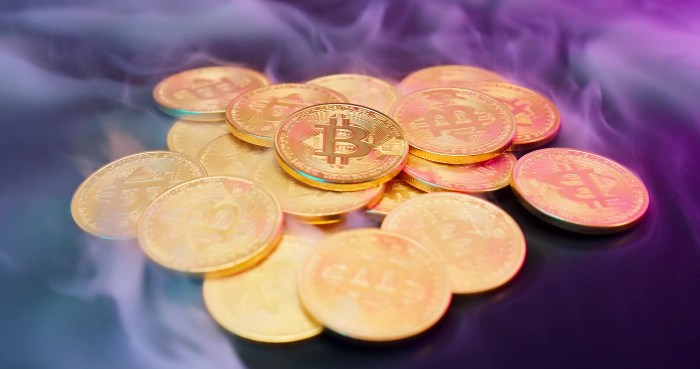 Monete Bitcoin dorate circondate dal fumo e dalla luce al neon