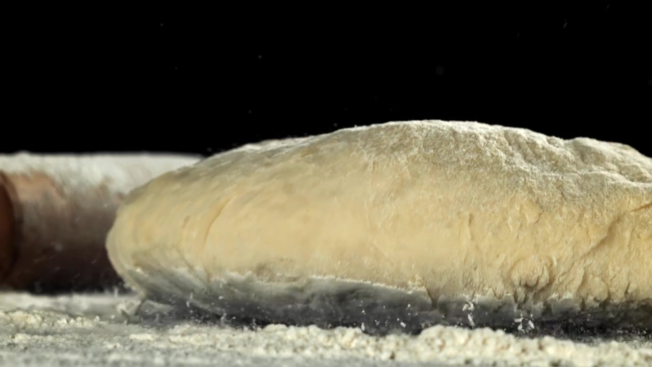 Impasto fresco che cade su una superficie infarinata al rallentatore
