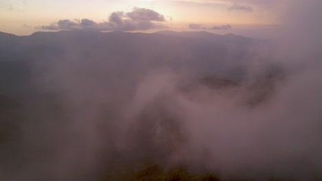 aerial push through clouds at sunset in blue ridge and appalachian mountain range
