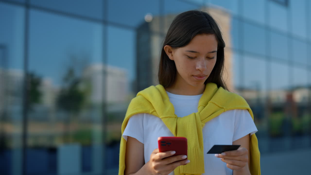 Young Woman Paying with Credit Card and Smartphone
