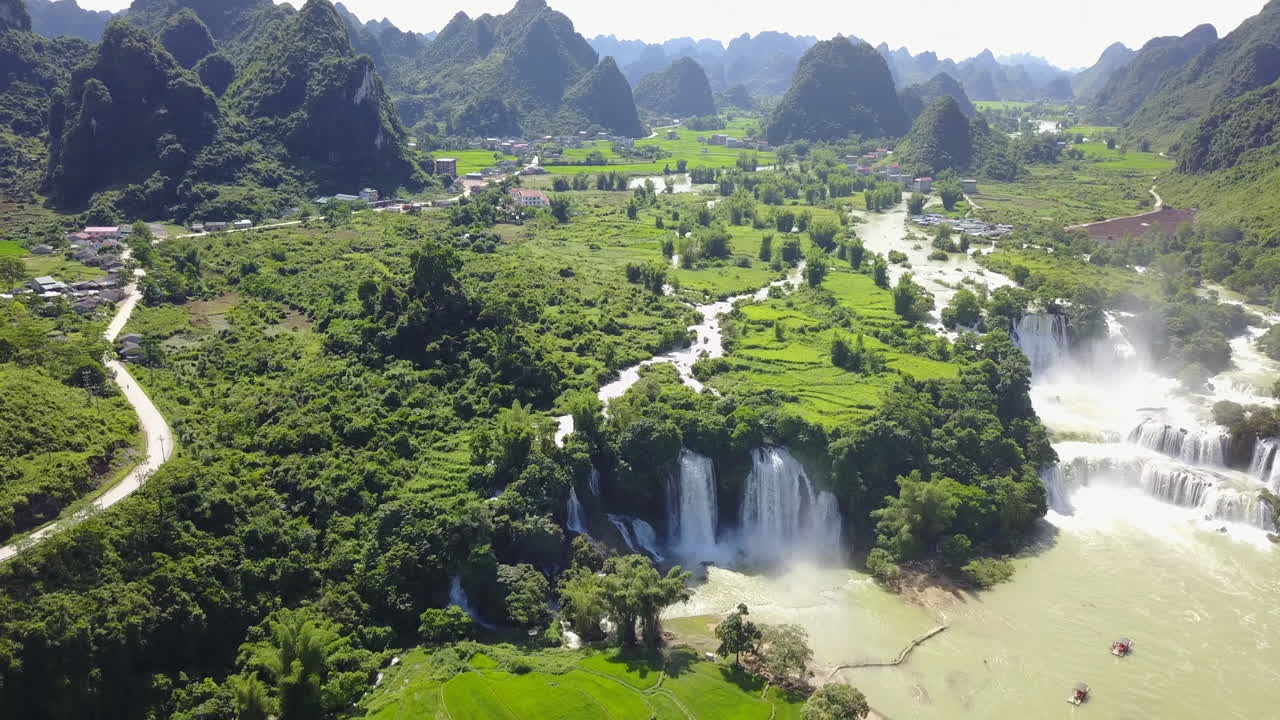 Lush green landscape with cascading Ban Gioc Waterfalls in a serene setting