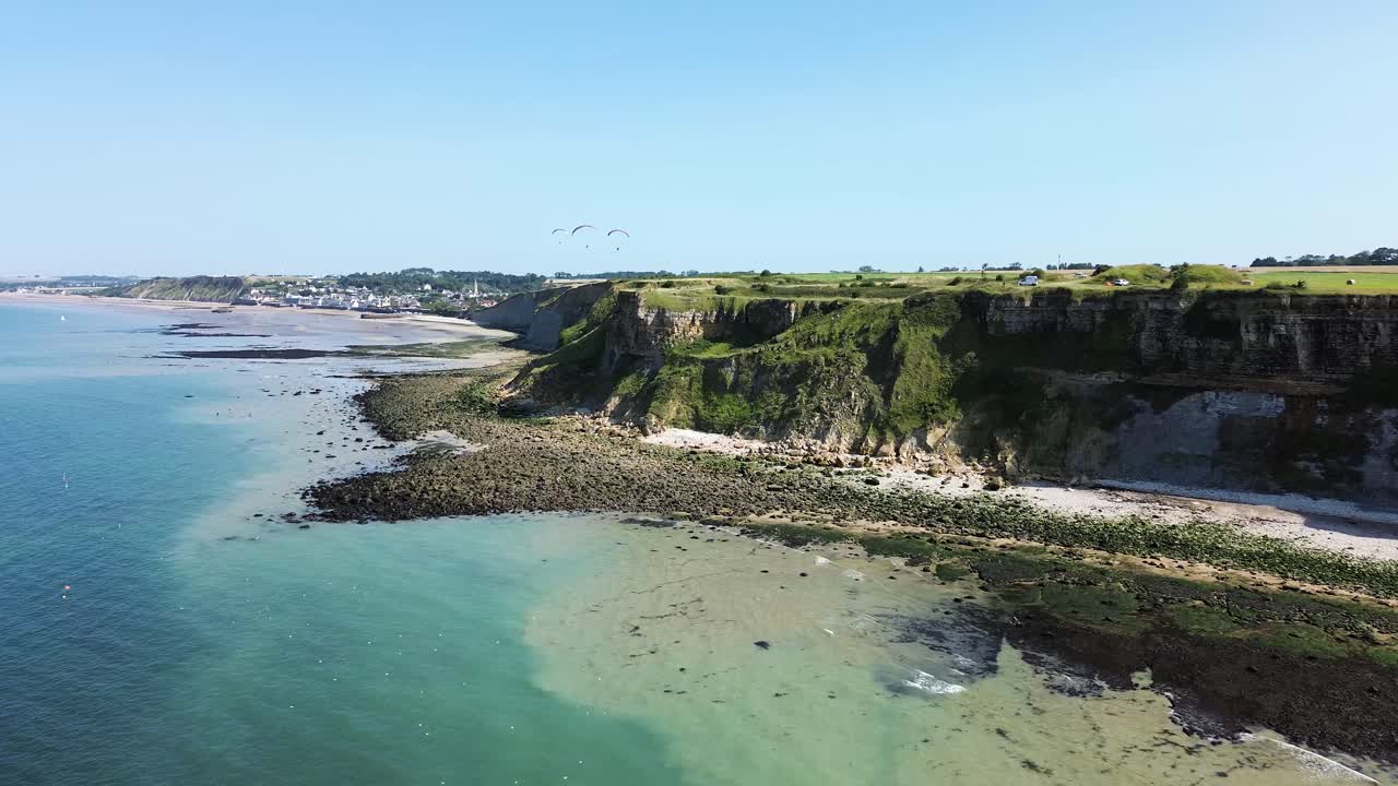 A stunning aerial view of the dramatic cliffs of Arromanches in Normandy, bathed in bright sunlight