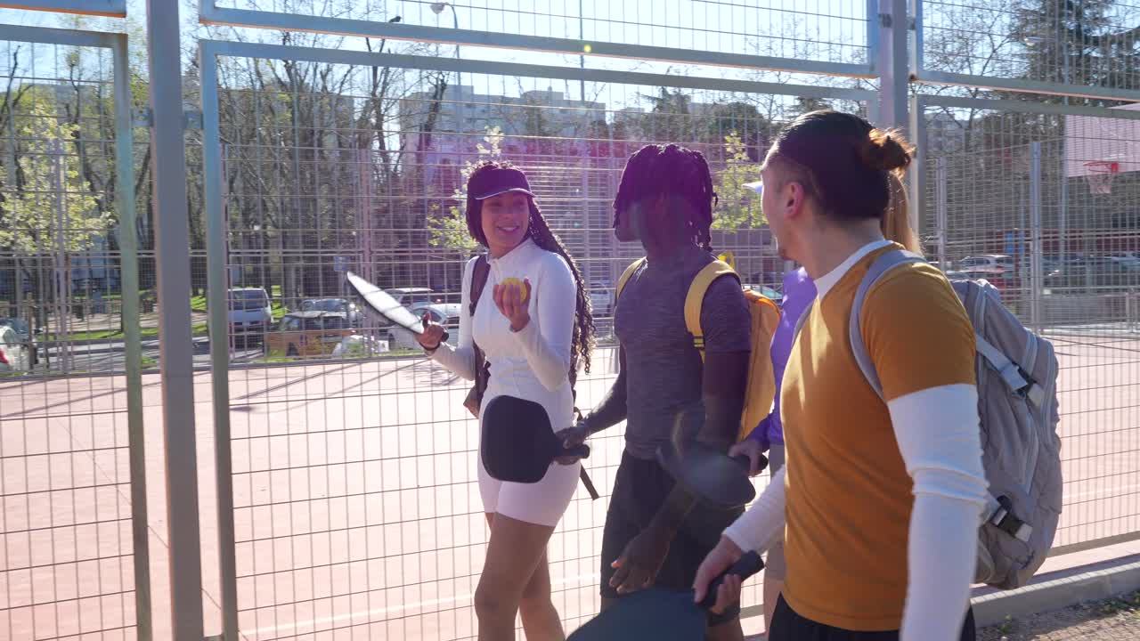 Groupe d'amis diversifié marchant pour jouer au pickleball par une journée ensoleillée