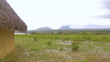 cabaña indígena pemon en mayupa, canaima, venezuela, con increíbles montañas tepuy en la parte trasera durante un día lluvioso