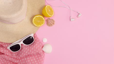 fashionable trendy beach accessories appear on pastel pink background. stop motion