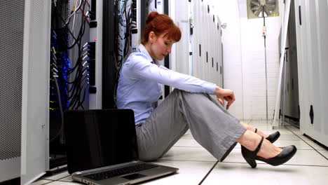 stressed technician sitting on floor beside open server