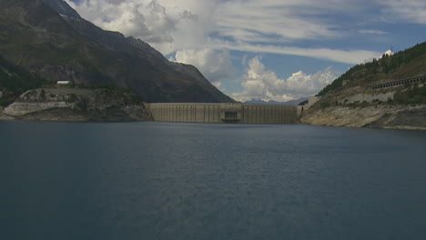 lake reservoir from hydro dam in vanoise national park, france - aerial drone flight