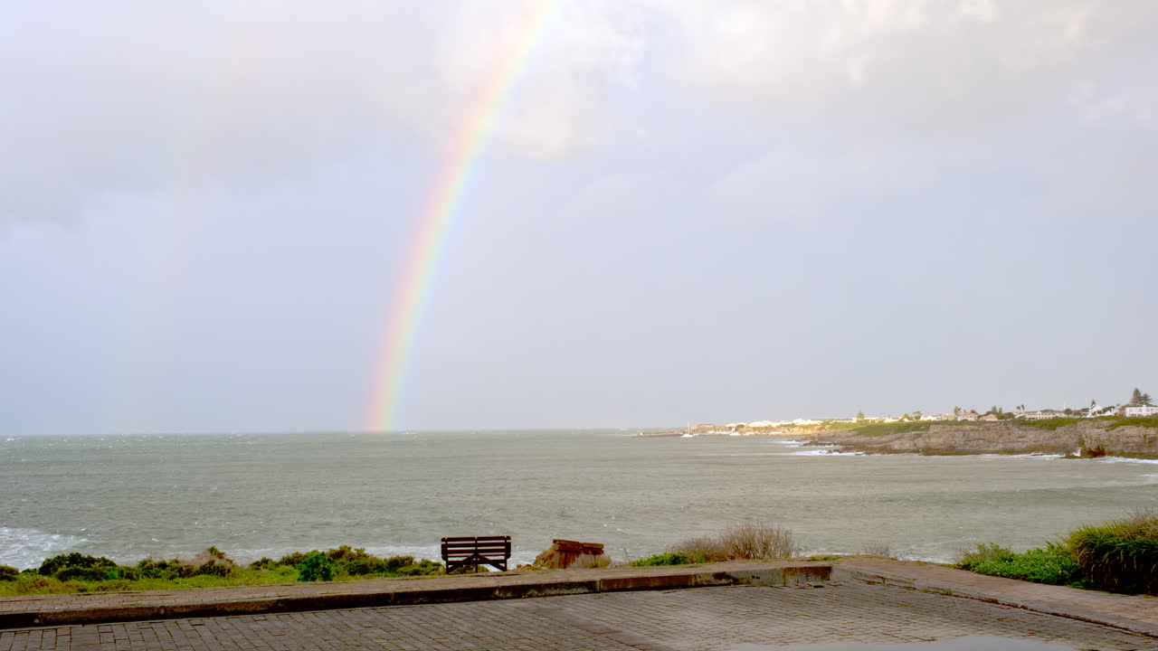 Rainbow over ocean in Hermanus on day with stormy weather, Cape Whale Coast